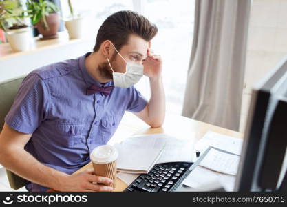 business, pandemic and health concept - businessman or creative male office worker wearing face protective medical mask for protection from virus disease with computer drinking coffee. office worker in mask with computer and coffee