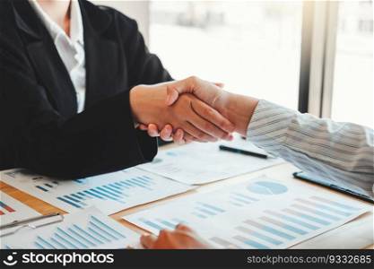 Business partner colleagues shaking hands meeting with new startup project plan Finance and Economy Graph with laptop successful teamwork