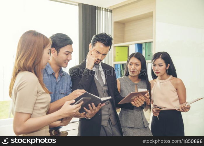 Business partner team meeting outdoor talking having fun together using smart tablet checking news and company email. Diversity multiethnic group of business people sitting outside talking teamwork