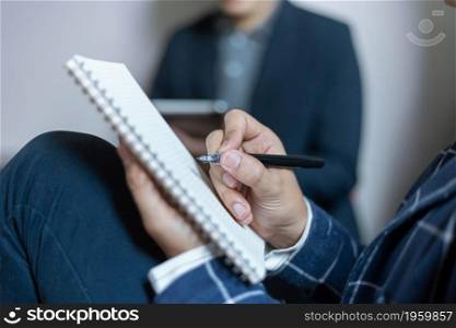 Business partners concept a young businessman holding a pen pointing at profit summary of the recent month showing in document forms.