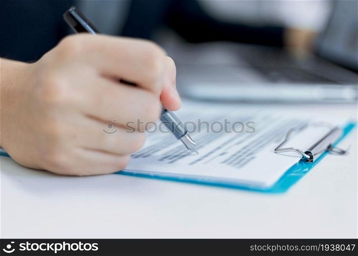 Business partners concept a young male entrepreneur signing a signature on the contract with a big company.
