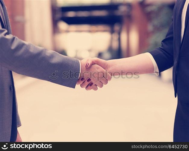 business partners concept with businessman and businesswoman handshake at modern office indoors