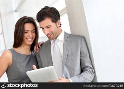Business partners working in hall on electronic tablet