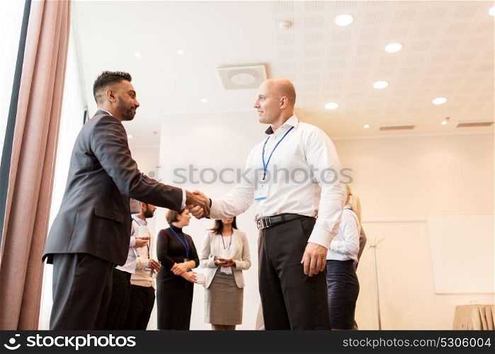 business, partnership and cooperation concept - handshake of people at international conference. handshake of people at business conference