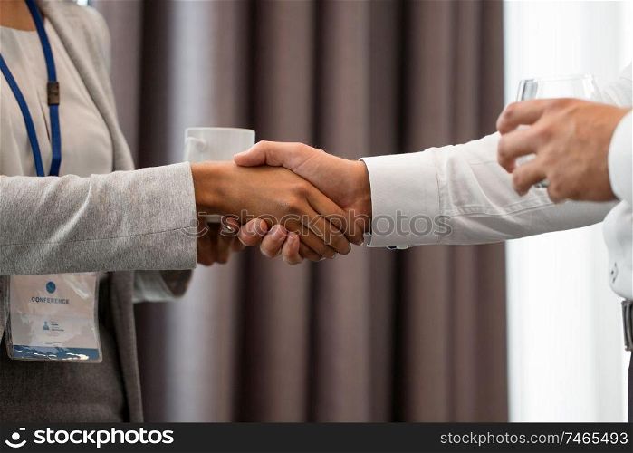 business, partnership and cooperation concept - handshake of people at international conference. handshake of people at business conference