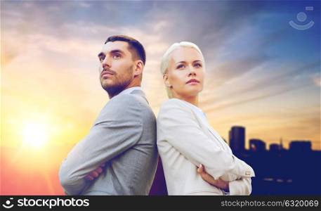 business, partnership and teamwork concept - businessman and businesswoman standing over city background. businessman and businesswoman outdoors