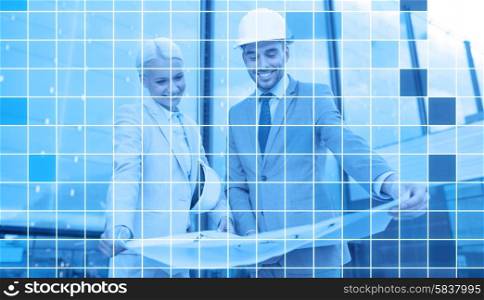 business, partnership, architecture and people concept - smiling businessman and businesswoman with blueprint and helmets over city street and blue monochrome grid background