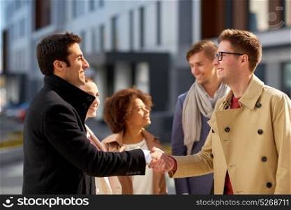 business, partnership, gesture and cooperation concept - happy people shaking hands on city street. happy people shaking hands on city street