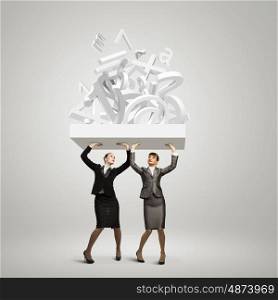 Business partnership. Image of two businesswomen holding burden above head