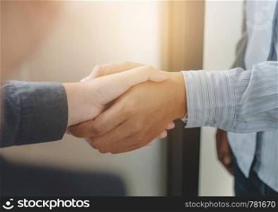 Business partnership meeting handshake in office room.