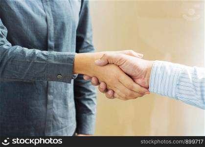 Business partnership meeting handshake in office room.
