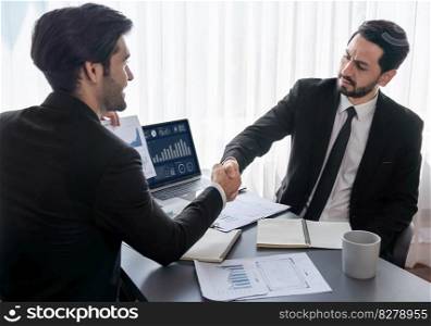 Business partnership meeting with successful trade agreement with handshake or greeting in corporate office desk. Businessman in black suit shaking hand after finalized business deal. Fervent. Business partnership with successful trade agreement with handshake. Fervent