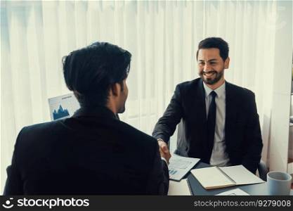 Business partnership meeting with successful trade agreement with handshake or greeting in corporate office desk. Businessman in black suit shaking hand after finalized business deal. Fervent. Business partnership with successful trade agreement with handshake. Fervent
