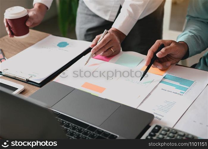 Business partnership pointing to the graph of the company financial statements report and profits earned during in the computer screen.