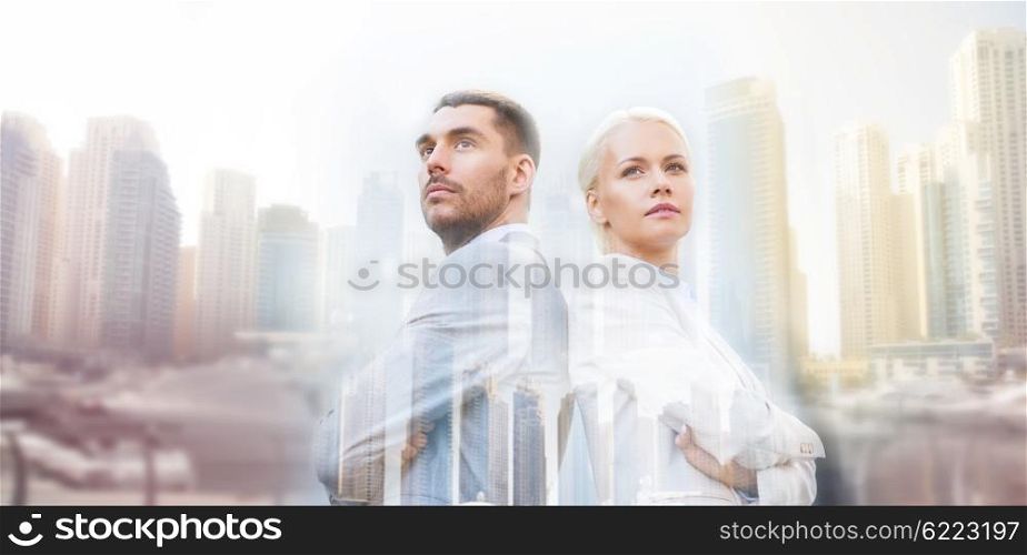 business, partnership, success and people concept - businessman and businesswoman standing over dubai city background with double exposure effect