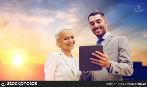 business, partnership, technology and people concept - smiling businessman and businesswoman with tablet pc computer over city background. smiling businessmen with tablet pc outdoors