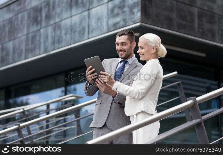 business, partnership, technology and people concept - smiling businessman and businesswoman working with tablet pc computer on city street