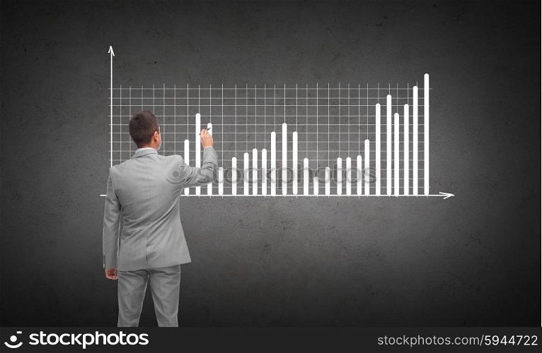 business, people, advertisement , information and office concept - businessman drawing diagram chart from back over dark gray concrete wall background