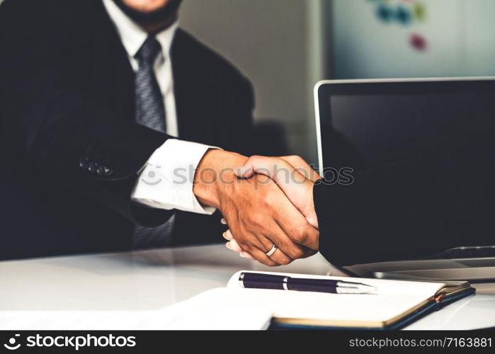 Business people agreement concept. Businessman and Asian businesswoman do handshake in the office.