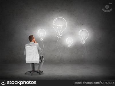 business, people and advertisement concept - businessman in suit sitting in office chair over blank white board or screen on gray wall background from back