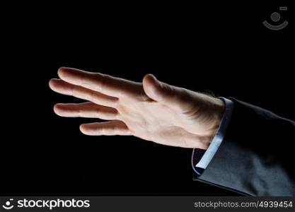 business, people and advertisement concept - close up of businessman hand over black background. close up of businessman hand over black background