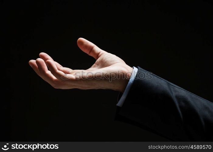 business, people and advertisement concept - close up of businessman with empty hand over black