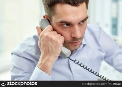 business, people and communication concept - face of angry businessman calling on phone in office