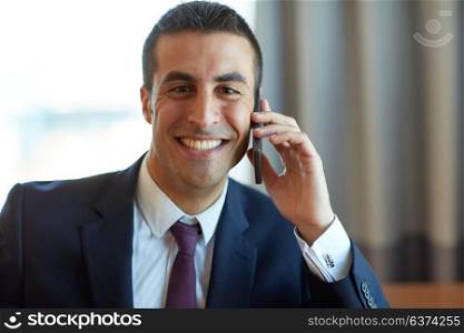 business, people and communication concept - happy smiling businessman calling on smartphone at hotel room. businessman calling on smartphone at hotel room