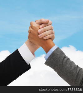 business, people and competition concept - close up of two people hands armwrestling over blue sky and white cloud background