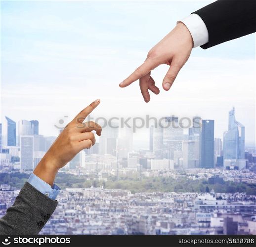 business, people and connection concept - close up of woman and man hands trying to connect over city background