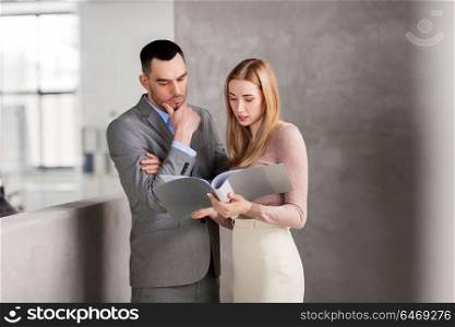 business, people and corporate concept - businesswoman and businessman with folder at office. businesswoman and businessman with folder