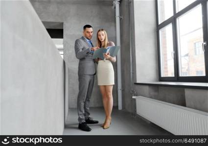 business, people and corporate concept - businesswoman and businessman with folder at office. businesswoman and businessman with folder. businesswoman and businessman with folder