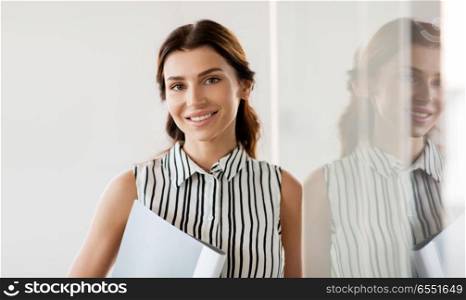 business, people and corporate concept - businesswoman or realtor with folder at office glass wall. businesswoman or realtor with folder at office. businesswoman or realtor with folder at office