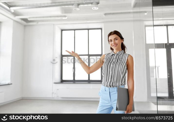 business, people and corporate concept - businesswoman or realtor with folder showing new office room. businesswoman or realtor with folder at office