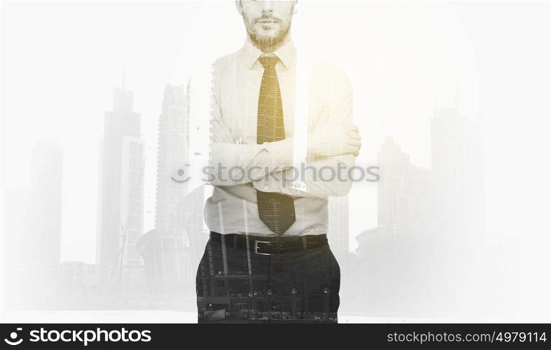business, people and corporate concept - handsome businessman with crossed arms over city buildings and double exposure effect. businessman with crossed arms over city buildings