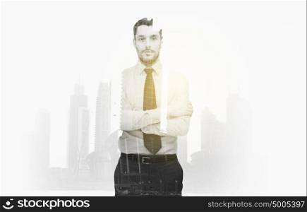 business, people and corporate concept - handsome businessman with crossed arms over city buildings and double exposure effect. businessman with crossed arms over city buildings