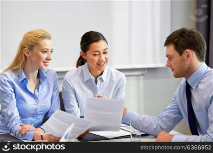 business, people and corporate concept - happy coworkers with papers working at office. happy business team with papers at office