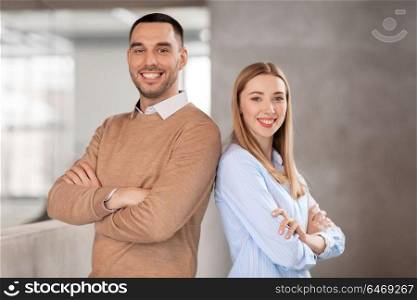 business, people and corporate concept - happy smiling businesswoman and businessman at office. smiling businesswoman and businessman at office