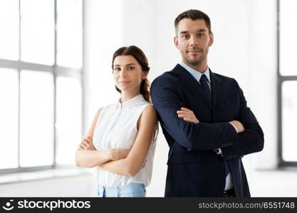 business, people and corporate concept - happy smiling businesswoman and businessman at office. smiling businesswoman and businessman at office. smiling businesswoman and businessman at office