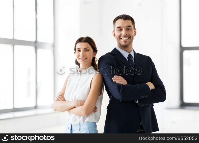 business, people and corporate concept - happy smiling businesswoman and businessman at office. smiling businesswoman and businessman at office. smiling businesswoman and businessman at office
