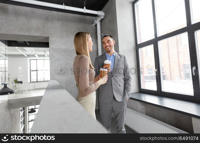 business, people and corporate concept - happy smiling businesswoman and businessman drinking coffee at office. businesswoman and businessman at coffee break. businesswoman and businessman at coffee break