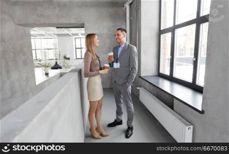 business, people and corporate concept - happy smiling businesswoman and businessman drinking coffee at office. businesswoman and businessman at coffee break. businesswoman and businessman at coffee break