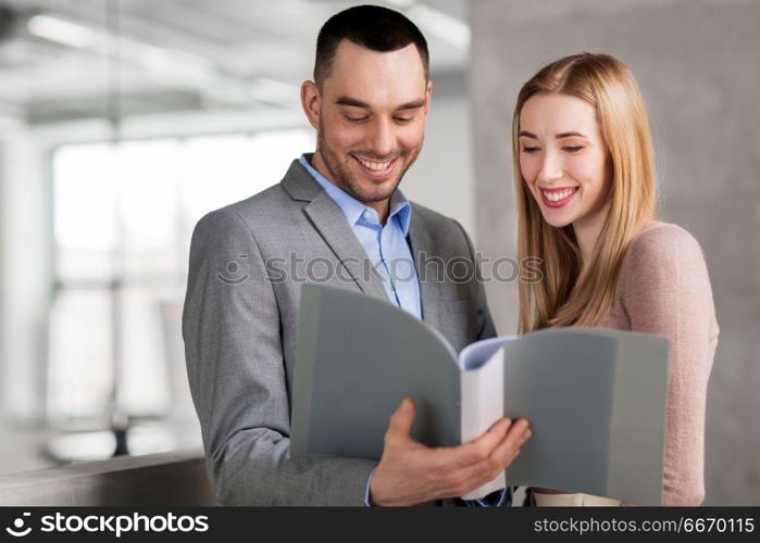 business, people and corporate concept - happy smiling businesswoman and businessman with folder at office. businesswoman and businessman with folder. businesswoman and businessman with folder