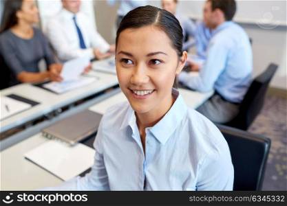 business, people and corporate concept - happy smiling young businesswoman at office. happy smiling young businesswoman at office