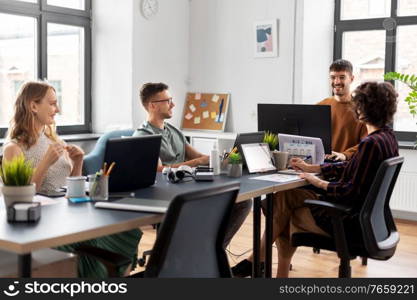 business, people and corporate concept - happy team of startuppers or ui designers working at office. business team or startuppers working at office