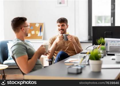 business, people and corporate concept - male startuppers drinking coffee at office. men or startuppers drinking coffee at office