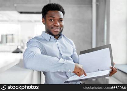 business, people and corporate concept - smiling african american businessman with folder at office. african american businessman with folder at office. african american businessman with folder at office