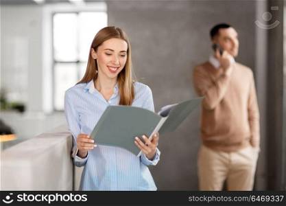 business, people and corporate concept - smiling female office worker with folder. smiling female office worker with folder