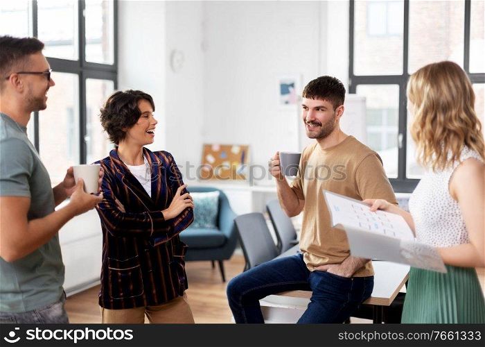 business, people and corporate concept - team of startuppers drinking coffee and talking at office. team of startuppers drinking coffee at office