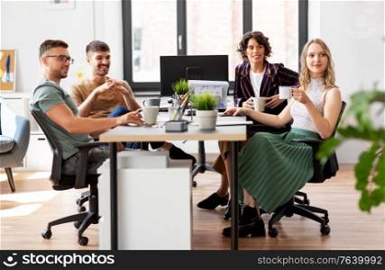 business, people and corporate concept - team of startuppers drinking coffee at office. team of startuppers drinking coffee at office